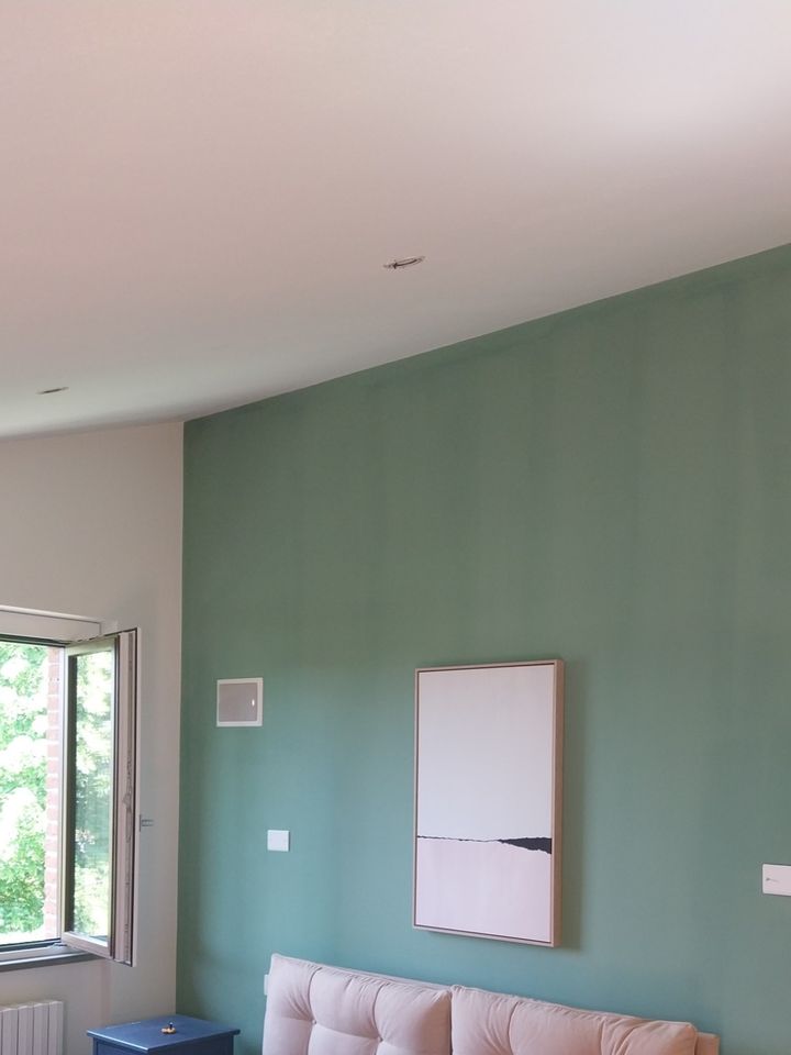 Bedroom with the wall behind the bed painted sage green