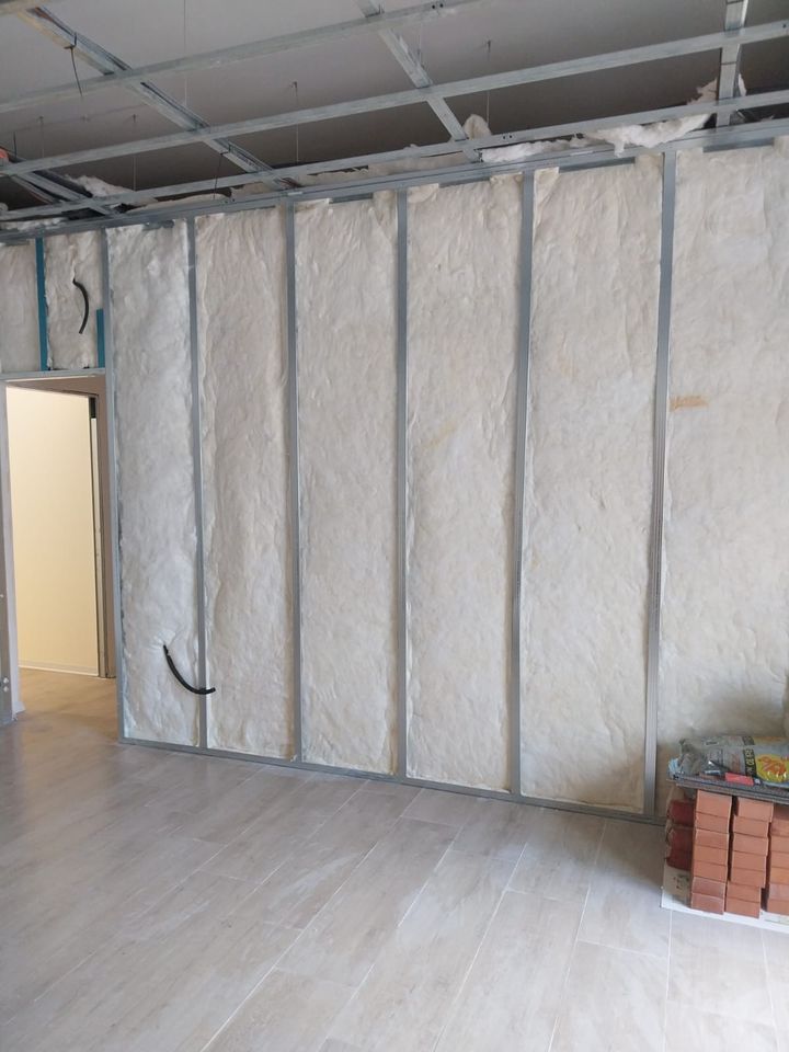 Plasterboard wall under construction: metal studs and insulation panels before the boards go on