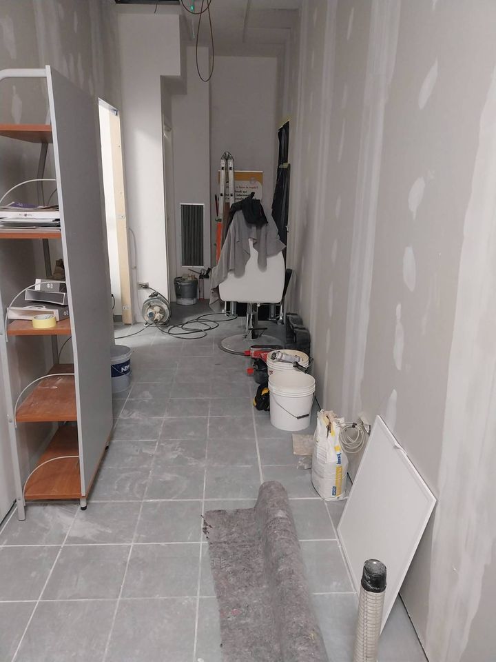Corridor with plasterboard walls and filled joints, tools and building materials